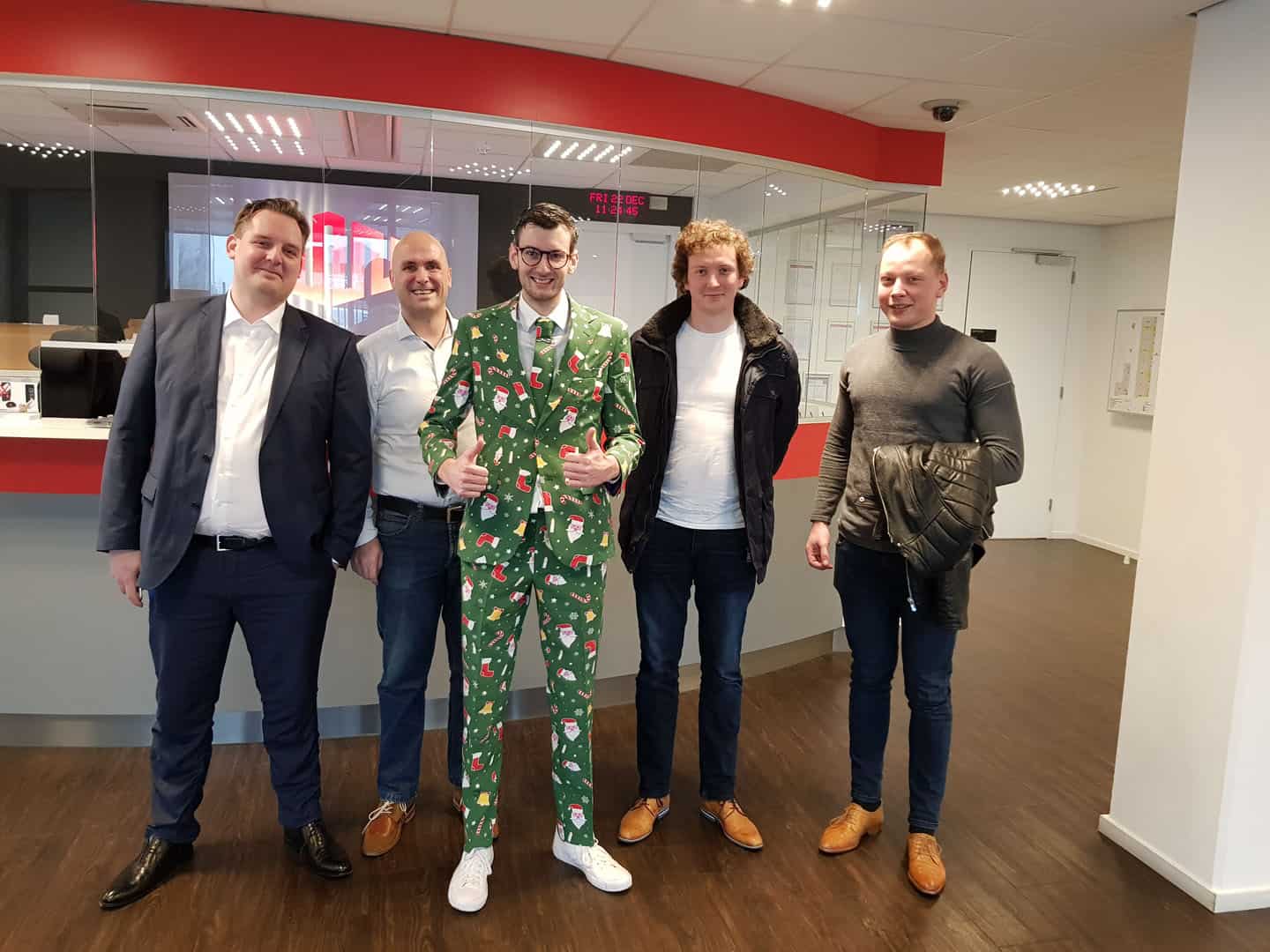 Vijf collega's poseren voor een kerstfoto