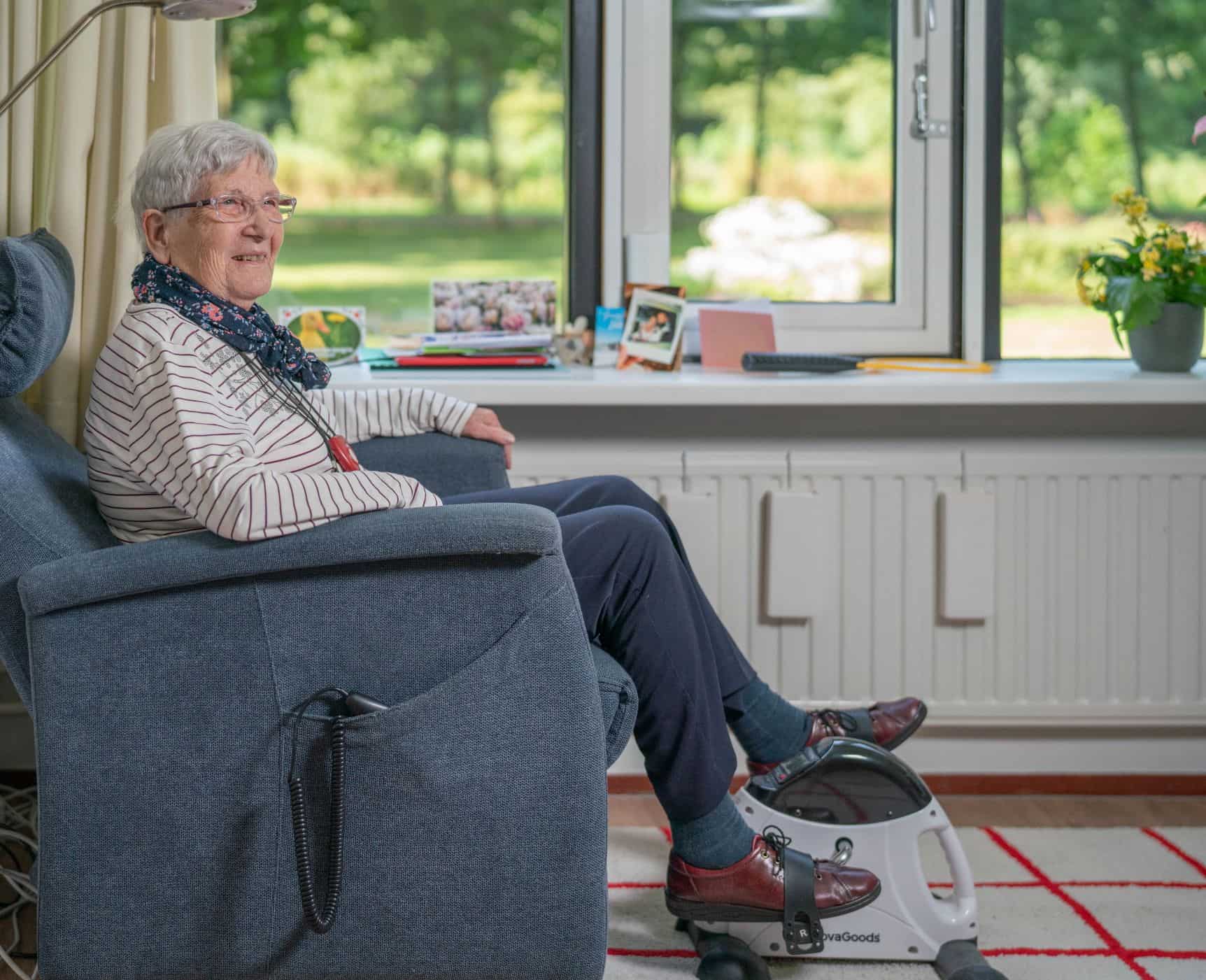 Een bewoner fietst op een hometrainer in haar kamer