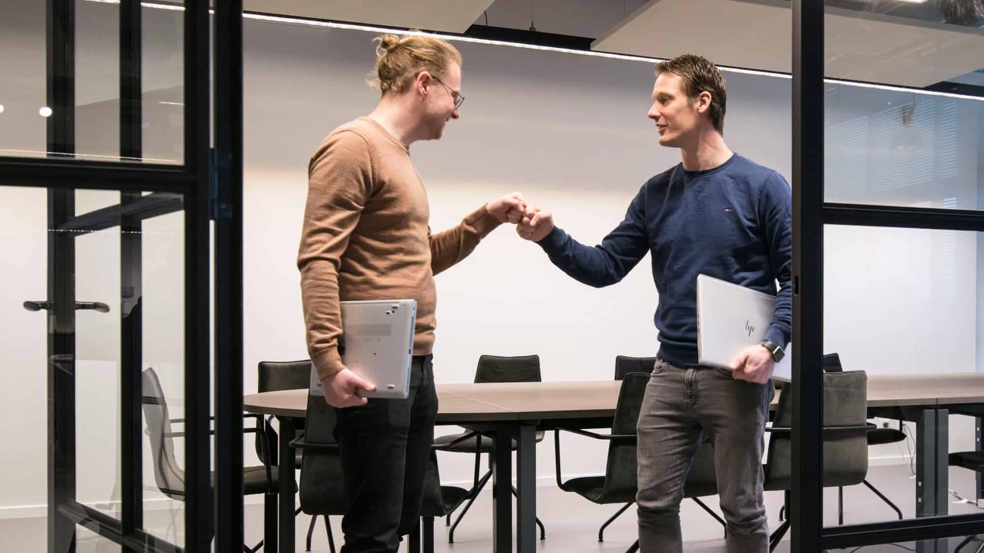 Twee collega's geven elkaar een hand na een geslaagde klus
