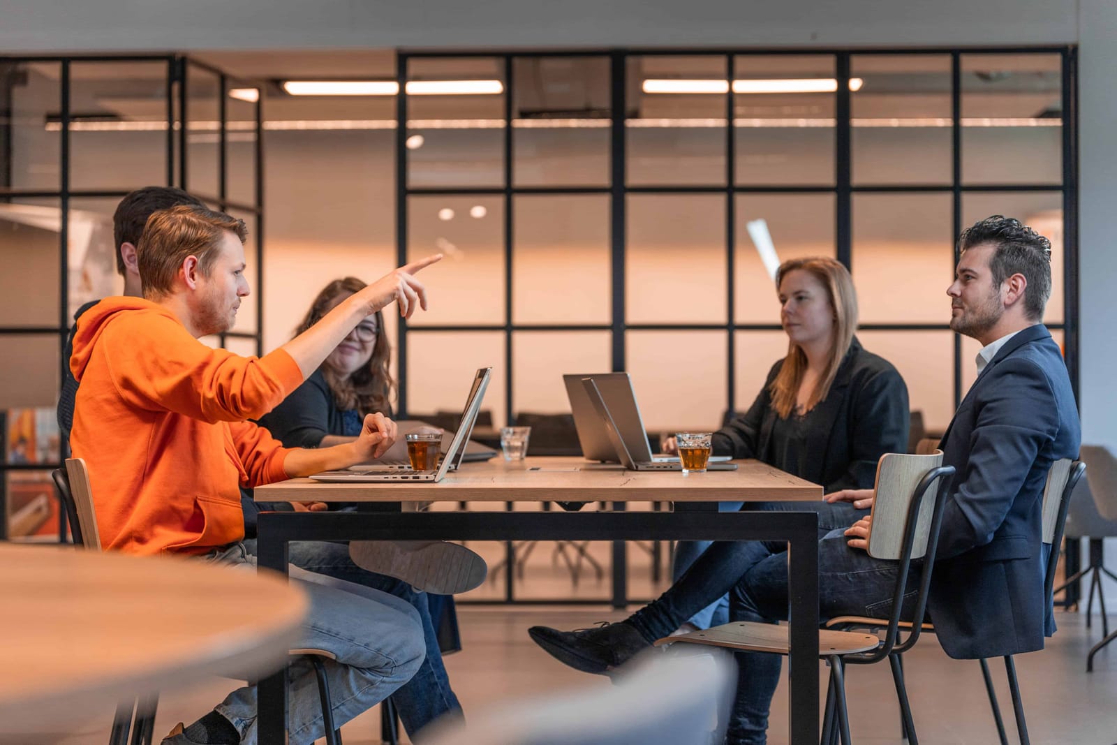 Collega's in overleg rond een tafel tijdens een bijeenkomst