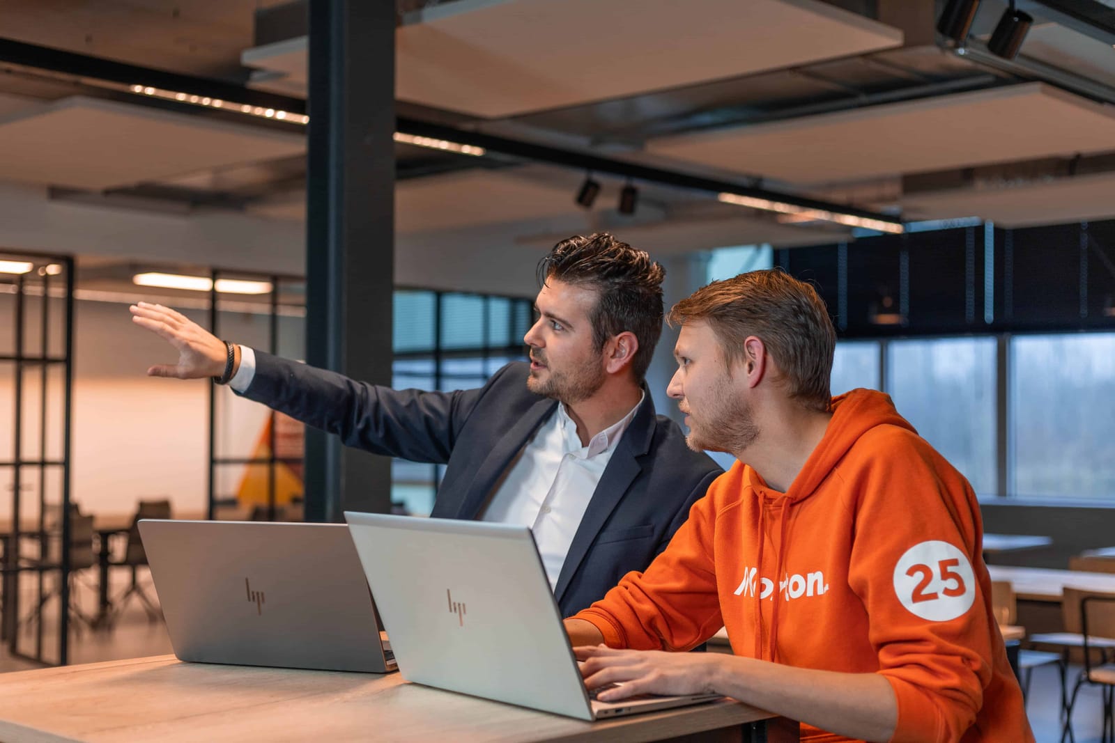 Een collega presenteert aan tafel tijdens een bijeenkomst