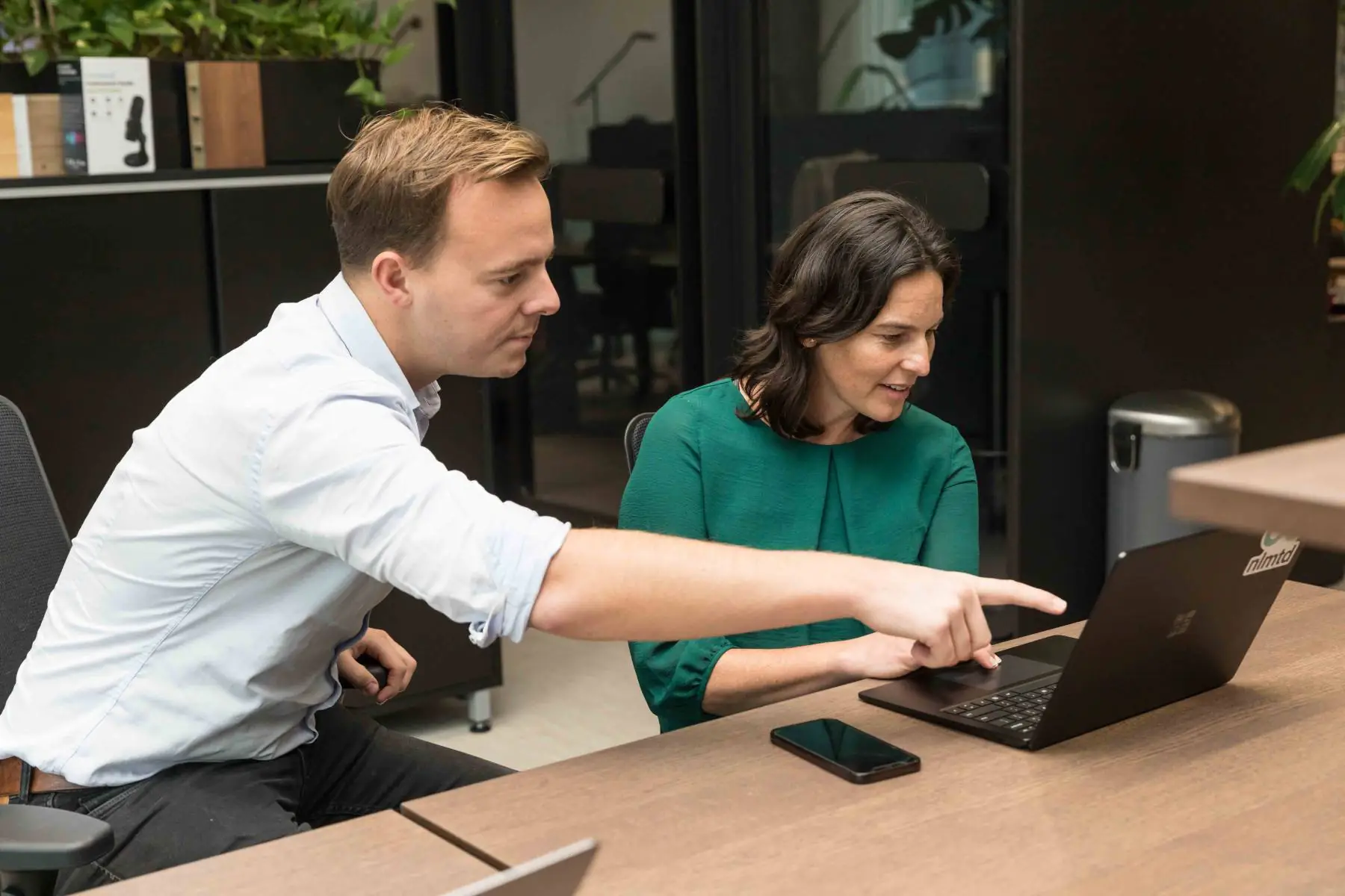 Twee mensen van nlmtd werken samen aan een laptop
