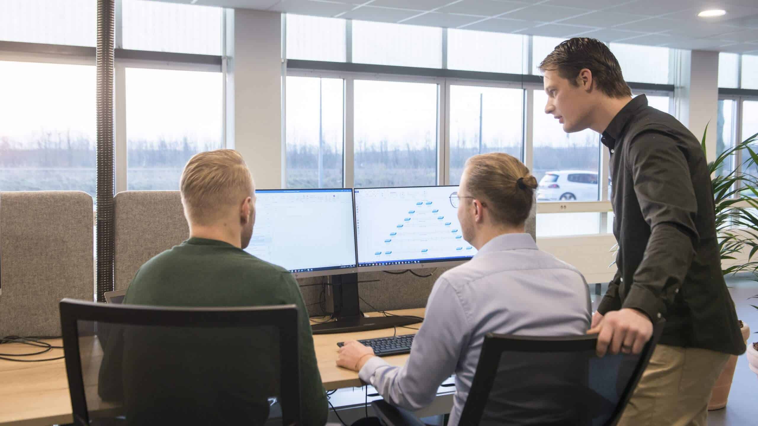 Collega's in gesprek aan een bureau bij het raam