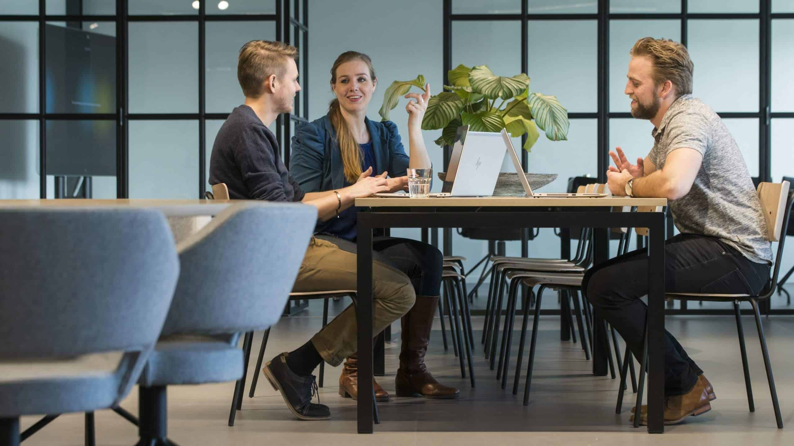 Vier collega's aan een lange tafel in de kantine