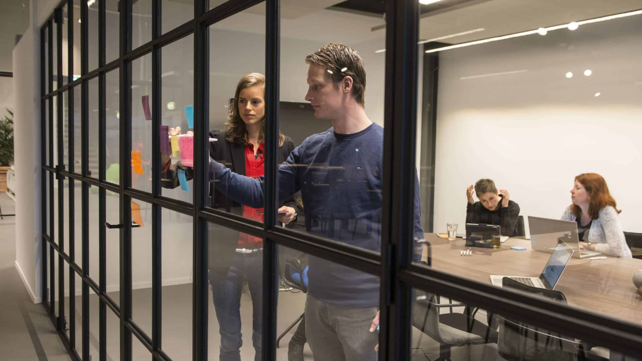 Collega's plannen het werk achter een glazen wand