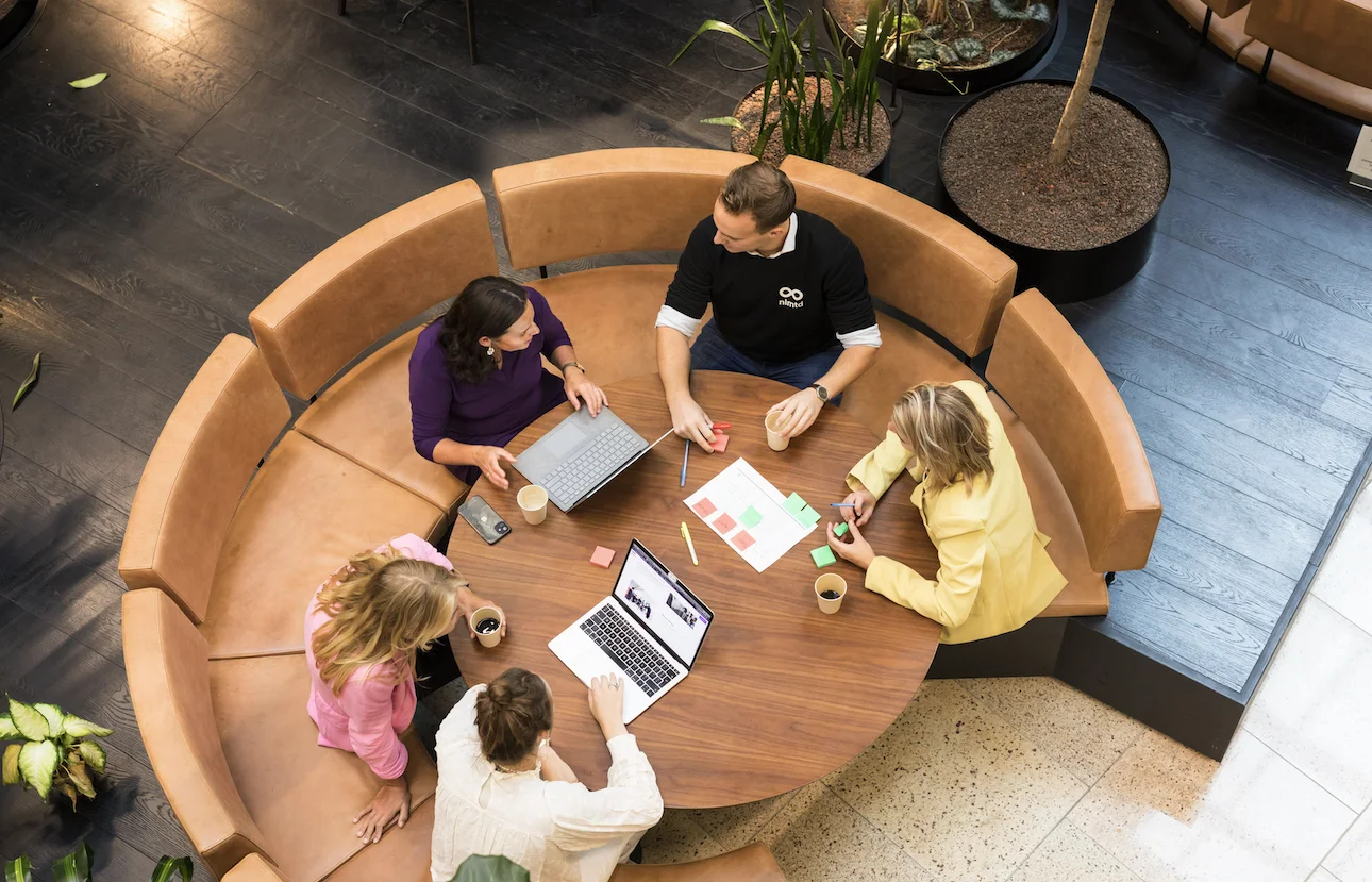 Collega's van nlmtd aan een ronde tafel