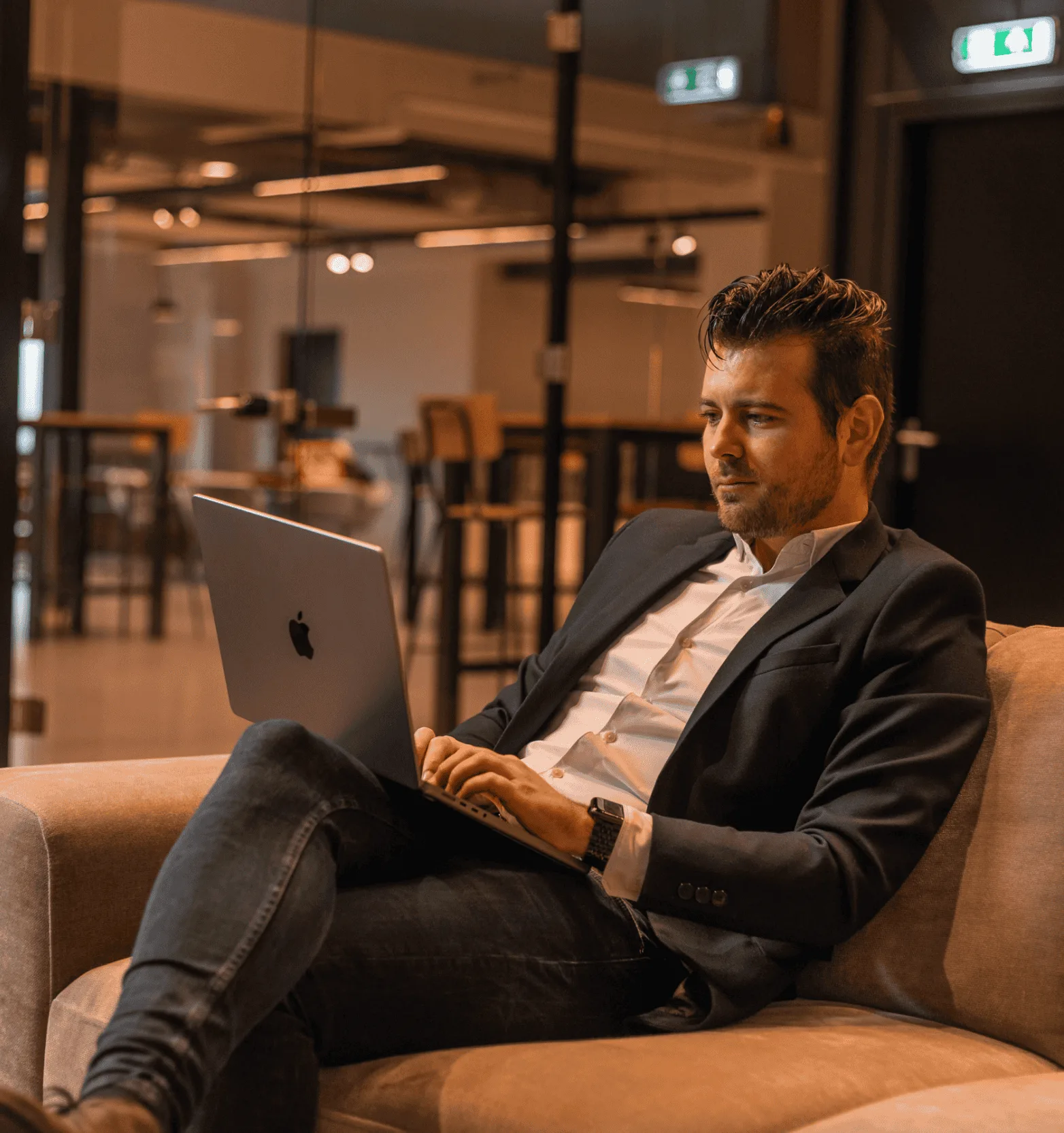 Een collega werkt met zijn laptop op een bank